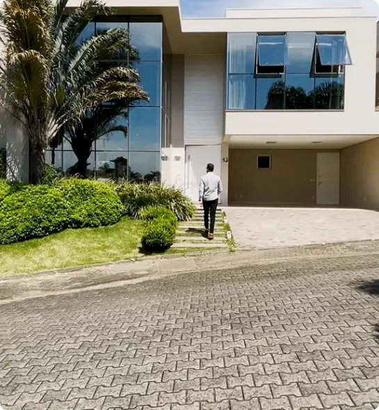 Gabriel Leão de costas para foto, de frente para uma casa